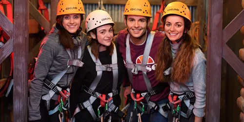 Group of friends with helmets and harnesses at The Bear Grylls Adventure High Ropes