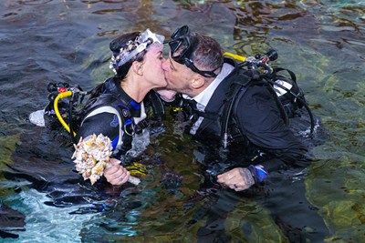 happy couple lisa and chris kiss after their underwater wedding at the Bear Grylls Adventure
