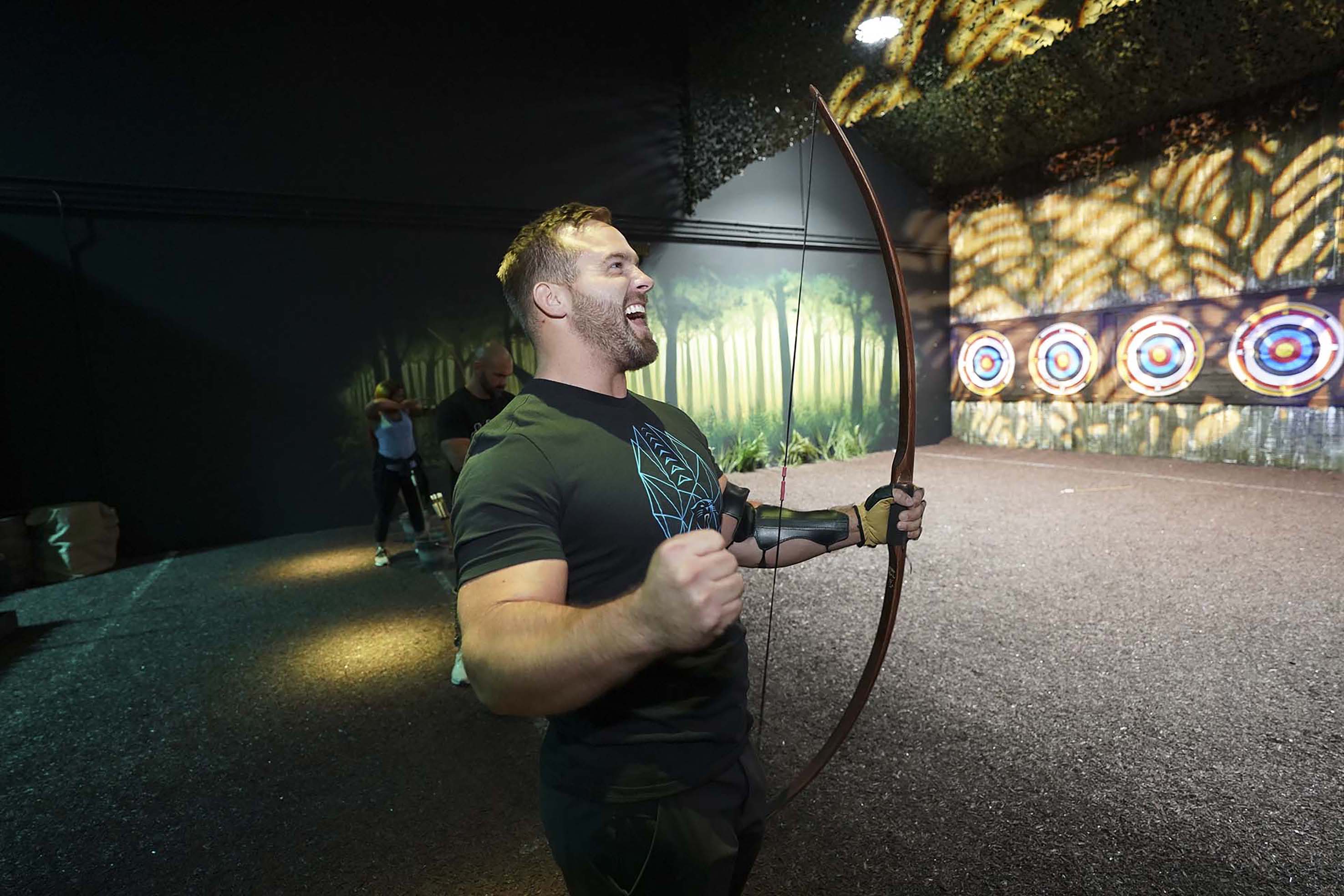 man with bow on archery range at The Bear Grylls Adventure