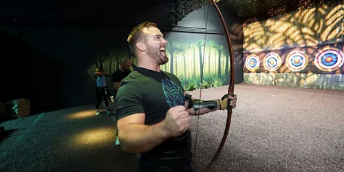 man with bow on archery range at The Bear Grylls Adventure